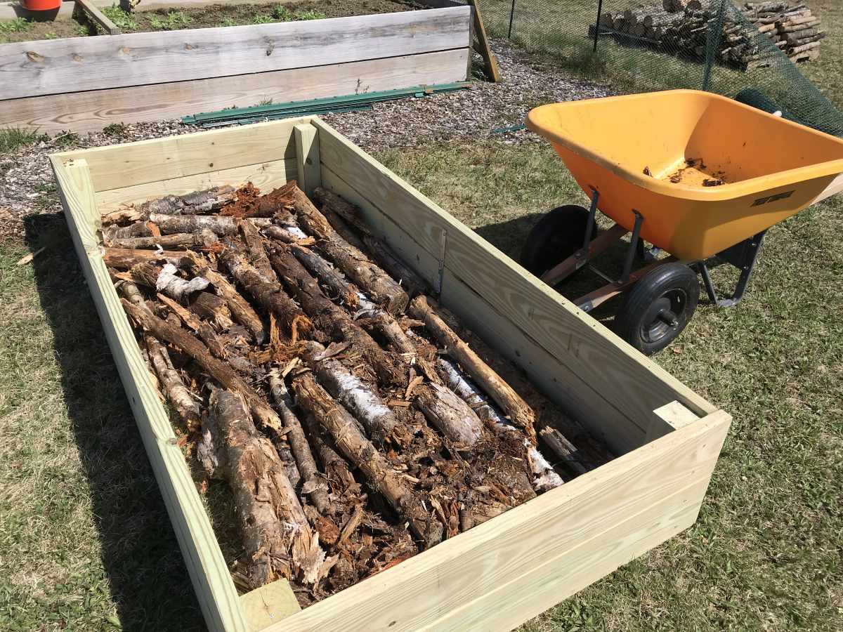 https://modernsurvivalblog.com/wp-content/uploads/2022/05/rotting-logs-in-bottom-of-garden-bed.jpg