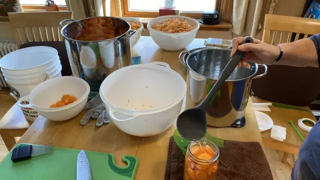 adding hot water to raw pack carrot canning jars